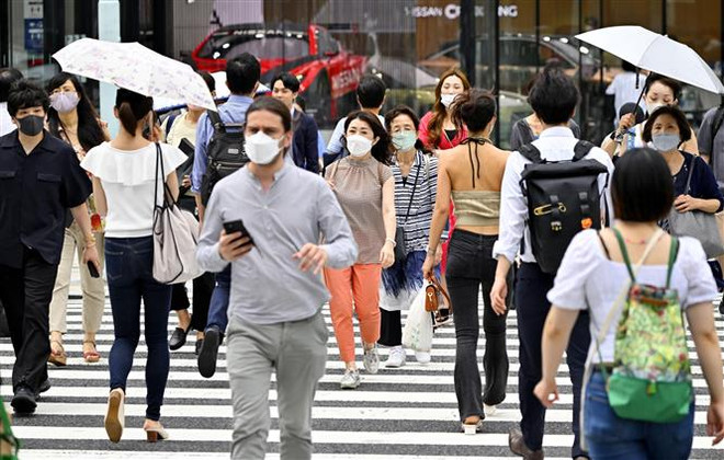 Người dân đeo khẩu trang phòng dịch COVID-19 khi di chuyển tại Tokyo, Nhật Bản. (Ảnh: Kyodo/TTXVN) Nhật Bản ghi nhận số ca mắc COVID-19 ở mức cao kỷ lục mới ảnh 1