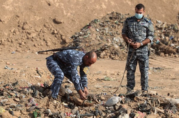Cảnh sát Iraq khai quật thi thể được tìm thấy trong một ngôi mộ tập thể ở Hamam al-Alil trong chiến dịch giải phóng Mosul ngày 7/11/2017. (Nguồn: AFP/TTXVN) Hơn 200 ngôi mộ tập thể nạn nhân của IS được phát hiện tại Iraq ảnh 1