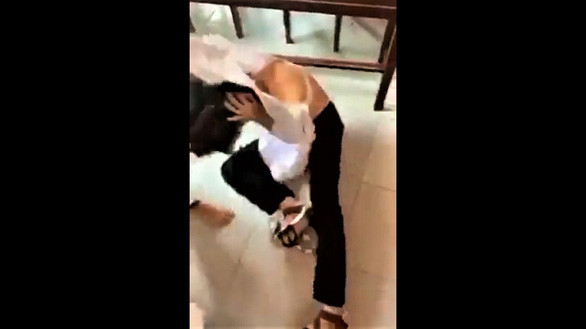 Nữ sinh bị nhóm bạn giật tóc, đánh ngã xuống nền gạch. (Ảnh: cắt từ clip) Bến Tre tạm đình chỉ học tập bốn nữ sinh đánh nhau tại lớp học ảnh 1