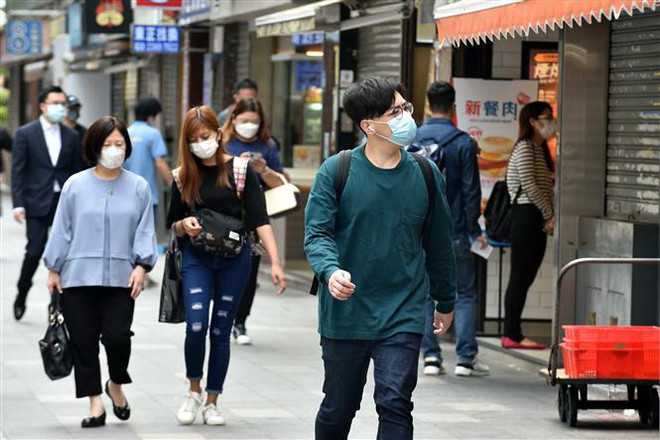 Người dân đeo khẩu trang phòng lây nhiễm COVID-19 tại Hong Kong, Trung Quốc. (Ảnh: THX/TTXVN) Hong Kong ngừng các chuyến bay từ Ấn Độ, Pakistan và Philippines ảnh 1