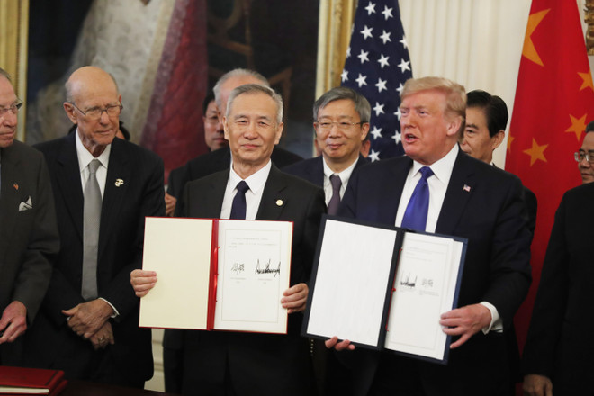 Tổng thống Mỹ Donald Trump (phải, phía trước) và Phó Thủ tướng Trung Quốc Lưu Hạc (trái, phía trước) tại lễ ký thỏa thuận thương mại giai đoạn một ở Washington DC., ngày 15/1/2020. (Ảnh: THX/TTXVN) COVID-19 buộc Mỹ-Trung điều chỉnh việc thực thi thỏa thuận thương mại? ảnh 1