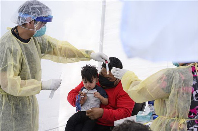 Lấy mẫu dịch xét nghiệm COVID-19 cho trẻ nhỏ. (Ảnh: AFP/TTXVN) Châu Âu ghi nhận nhiều ca mắc hội chứng liên quan COVID-19 ở trẻ em ảnh 1