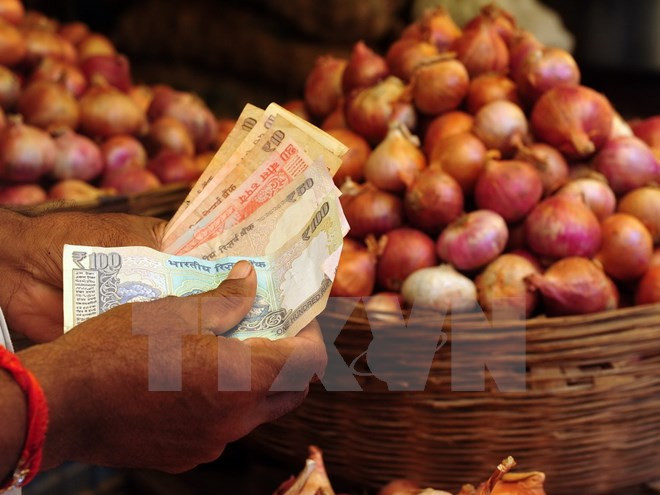 Người dân mua bán hành tại khu chợ ở Mumbai. (Nguồn: AFP/TTXVN) WB: Ấn Độ sẽ đuổi kịp Trung Quốc về tốc độ tăng trưởng kinh tế ảnh 1