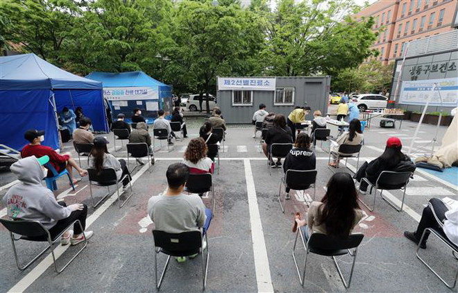 Người dân xếp hàng chờ xét nghiệm COVID-19 tại Seoul, Hàn Quốc ngày 12/5/2020. (Ảnh: Yonhap/TTXVN) Hàn Quốc xem xét mở rộng dịch vụ khám và chữa bệnh từ xa ảnh 1