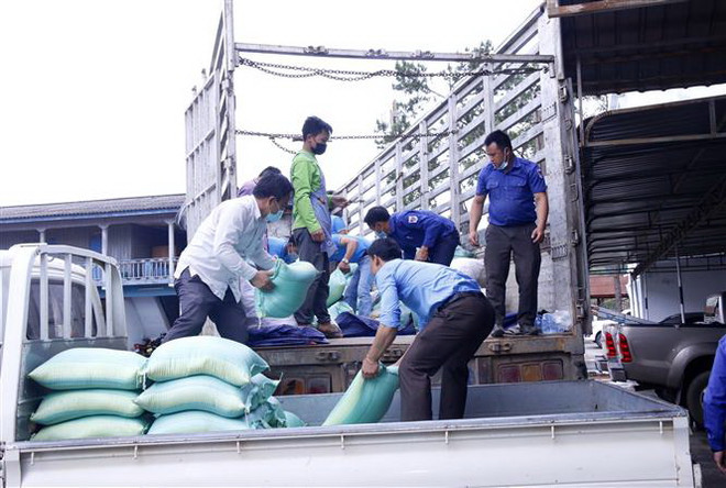 Hàng hóa quyên góp từ khắp các tổ chức và người dân trong tỉnh đang được bốc lên xe chuyển về Thành phố Hồ Chí Minh. (Ảnh: Phạm Kiên/TTXVN) Tỉnh Xiengkhouang của Lào chia sẻ khó khăn với nhân dân TP. HCM ảnh 1