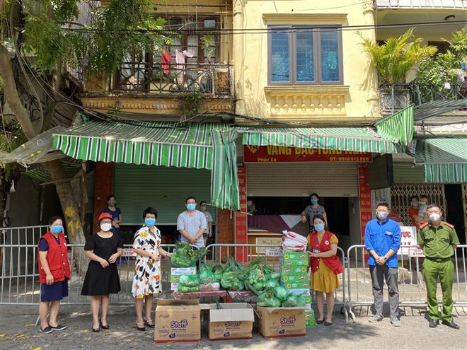 Điểm phát hàng miễn phí nhu yếu phẩm cho người lao động nghèo, người yếu thế. (Ảnh TTXVN phát) Hà Nội góp sức chăm lo cho người yếu thế trong thời đại dịch ảnh 1
