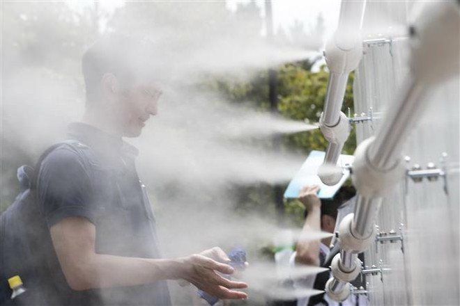 Người dân làm mát do nắng nóng tại Tokyo ngày 25/7/2019. (Ảnh: AFP/TTXVN) NOAA: Tháng 7 năm nay là tháng nóng nhất trong lịch sử Trái Đất ảnh 1