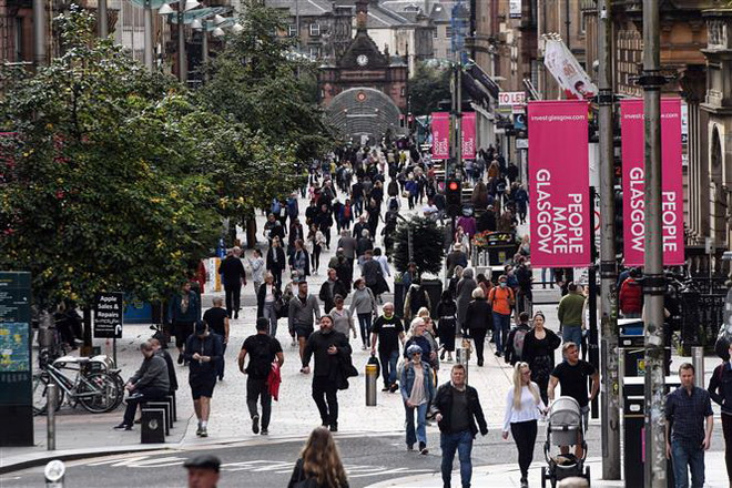 Người dân di chuyển trên đường phố tại Glasgow, Anh. (Ảnh: AFP/TTXVN) Anh ghi nhận số ca mắc cao nhất từ khi xảy ra đại dịch COVID-19 ảnh 1