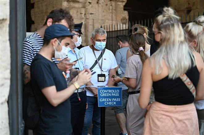 Nhân viên an ninh kiểm tra chứng nhận COVID-19 của khách tham quan tại Rome, Italy. (Ảnh: AFP/TTXVN) Liên minh châu Âu đạt mục tiêu tiêm chủng cho 70% người trưởng thành ảnh 1