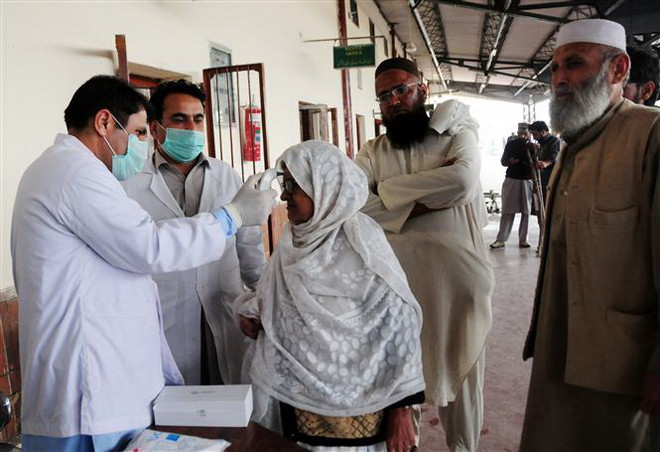Kiểm tra thân nhiệt phòng lây nhiễm dịch COVID-19 tại Peshawar, Pakistan. (Ảnh: THX/TTXVN) IMF thông qua gói viện trợ khẩn cấp gần 1,4 tỷ USD cho Pakistan ảnh 1