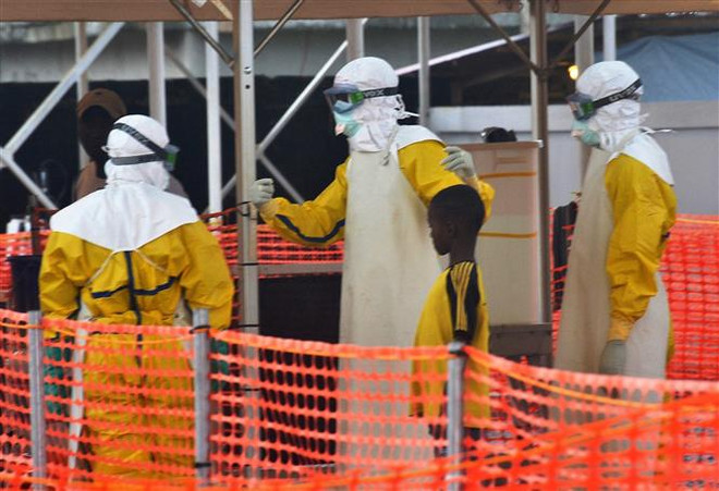Nhân viên y tế hướng dẫn bệnh nhân nhiễm virus Ebola. (Ảnh minh họa. AFP/TTXVN) Bờ Biển Ngà phát hiện ca nhiễm virus Ebola đầu tiên trong 25 năm qua ảnh 1