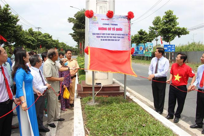 Ban tổ chức tiến hành mở băng khánh thành biển công trình “Đường cờ Tổ quốc”. (Ảnh: Trung Kiên/TTXVN) Chi hơn 1 tỷ đồng xây dựng “Đường cờ Tổ quốc” dài nhất nước ảnh 1