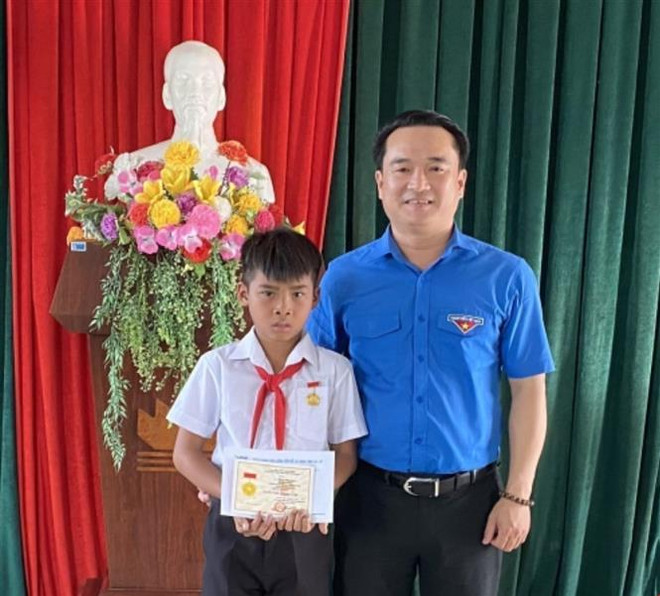 Trao tặng Huy hiệu Tuổi trẻ dũng cảm cho em Kpă Nguyên, học sinh lớp 4 cứu người đuối nước tại Gia Lai. (Ảnh: TTXVN phát) Học sinh lớp 4 cứu 2 người đuối nước nhận Huy hiệu Tuổi trẻ dũng cảm ảnh 1