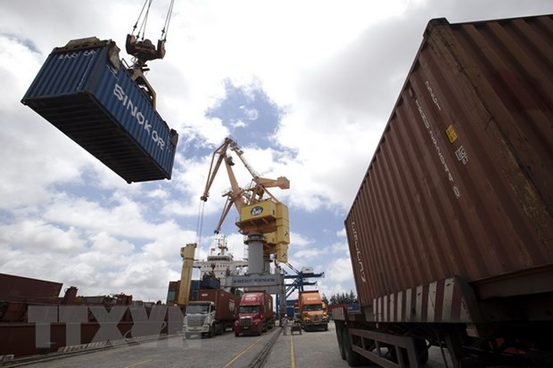 Các container được bốc xếp từ xe chở chuyên dụng lên tàu chở hàng. (Ảnh: Tuấn Anh/TTXVN) Thủ tướng yêu cầu hỗ trợ doanh nghiệp xuất khẩu hồ tiêu sang UAE ảnh 1