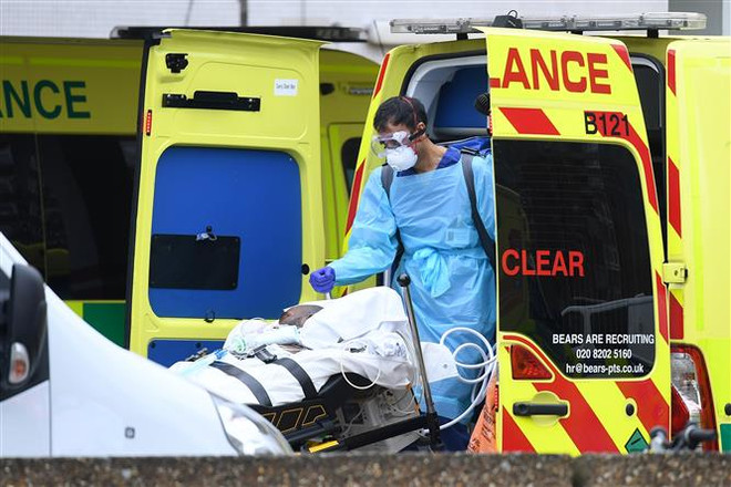 Nhân viên y tế chuyển bệnh nhân nhiễm COVID-19 tới bệnh viện St Thomas ở Bắc London, Anh ngày 13/4/2020. (Ảnh: THX/TTXVN) Chính phủ Anh gặp khó khi nguồn cung thiết bị bảo hộ thiếu hụt ảnh 1