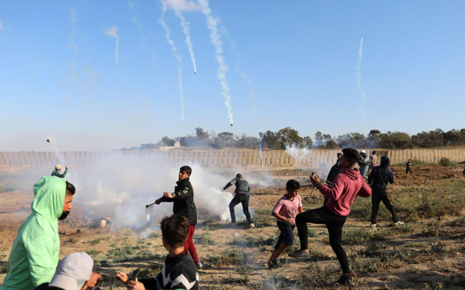 Binh sỹ Israel bắn đạn hơi cay về phía người biểu tình Palestine trong cuộc đụng độ tại khu vực biên giới Israel và Dải Gaza ngày 19/4. (Ảnh: THX/TTXVN) Đụng độ binh sỹ Israel tại Gaza, ít nhất 60 người Palestine bị thương ảnh 1