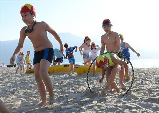 Các em trong nhóm cứu hộ nhí Nippers Đà Nẵng hào hứng với môn chạy vượt chướng ngại vật trên cát. (Ảnh: Quốc Dũng/TTXVN) Mùa hè bổ ích cho thiếu nhi qua các hoạt động giáo dục kỹ năng sống ảnh 2