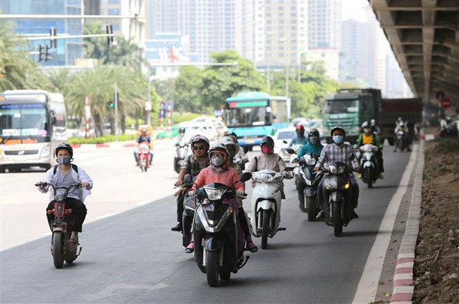 Người tham gia giao thông phải tránh nắng dưới bóng râm của gầm cầu trên tuyến đường Phạm Hùng. (Ảnh: Thành Đạt/TTXVN) Bắc Bộ ngày nắng nóng và đêm mưa dông, Trung Bộ tiếp tục nắng gắt ảnh 1