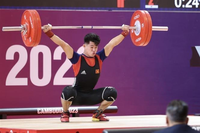 Vận động viên Trần Minh Trí thực hiện phần thi cử đẩy ở lượt cử cuối với mức tạ 176kg, phá kỷ lục SEA Games. (Ảnh: Minh Quyết/TTXVN) Vận động viên cử tạ Trần Minh Trí phá kỷ lục SEA Games ảnh 1