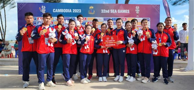 Đội tuyển Đua thuyền giành huy chương Vàng ở nội dung Thuyền 12 người nam nữ 500m - tấm huy chương Vàng thứ 2 tại kỳ SEA Games này. (Ảnh: TTXVN) SEA Games 32: Đua thuyền truyền thống gây bất ngờ lớn sau 20 năm ảnh 1