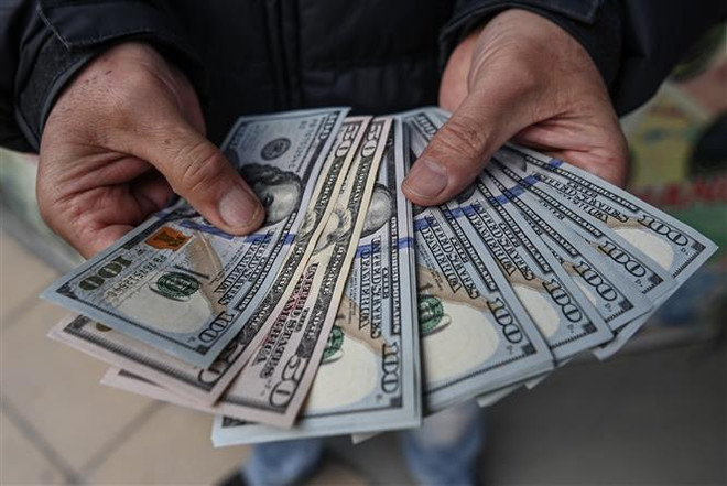 Kiểm đếm đồng USD. (Ảnh: AFP/TTXVN) Thỏa thuận về trần nợ là nhân tố tiêu cực với thị trường tài chính ảnh 1