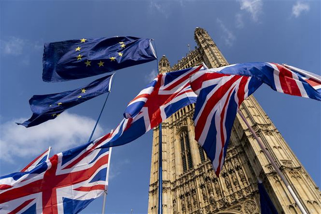 Cờ Anh (phía dưới) và cờ EU (phía trên). (Ảnh: AFP/ TTXVN) Khảo sát mới: Dư luận Anh ủng hộ thiết lập quan hệ gần gũi với EU ảnh 1