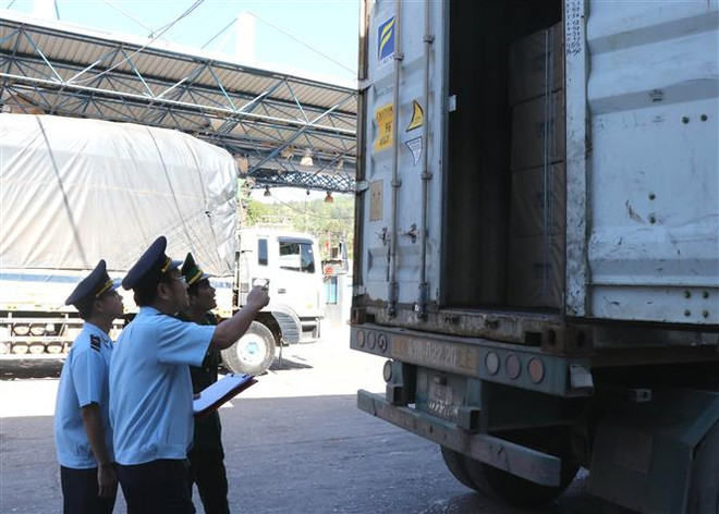 Lực lượng hải quan và biên phòng kiểm tra hàng hóa trên xe Container tại Cửa khẩu Quốc tế Lao Bảo. (Ảnh: Nguyên Lý/TTXVN) Quảng Trị hợp tác kinh tế cửa khẩu gắn với hành lang Đông-Tây ảnh 1