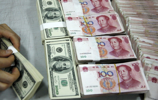 Kiểm tiền nhân dân tệ (phải) và đồng USD (trái) tại ngân hàng ở tỉnh An Huy, Trung Quốc. (Nguồn: AFP/TTXVN) Mỹ bổ sung danh sách các nước cần giám sát chính sách tiền tệ ảnh 1
