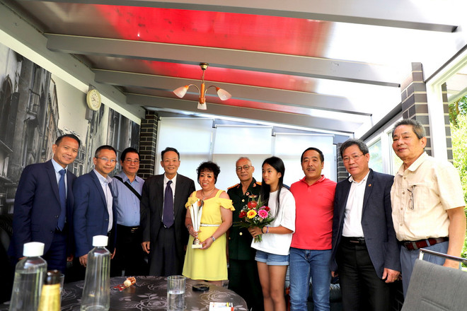 Ông Lê Hồng Cường, Chủ tịch Hội Tân Trào tặng kỷ niệm chương chị Nguyễn Lan Hương (váy vàng), con liệt sỹ Nguyễn Hồng Kỳ hy sinh tại chiến trường Campuchhia. (Ảnh: Phương Hoa/TTXVN) ttxvn-duc2.jpg
