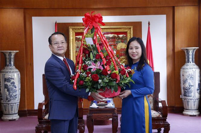 Ông Somdy Bounkhoun, Phó Trưởng Ban Đối ngoại Trung ương Đảng Nhân dân cách mạng Lào tặng hoa chúc mừng Đại biện lâm thời Đại sứ quán Việt Nam tại Lào Trịnh Thị Tâm. (Ảnh: Phạm Kiên/TTXVN) Lãnh đạo bộ, ngành của Lào chúc mừng ngày thành lập ĐCS Việt Nam ảnh 2