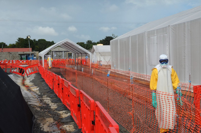 Nhân viên y tế trong trang phục bảo hộ cá nhân (PPE) bên ngoài trung tâm chữa trị Ebola do tổ chức phi chính phủ Bác sỹ không biên giới (MSF) điều hành tại thủ đô Monrovia, Liberia ngày 27/10. (Ảnh: AFP/TTXVN) Ngân hàng thế giới hỗ trợ thêm 100 triệu USD chống dịch Ebola ảnh 1