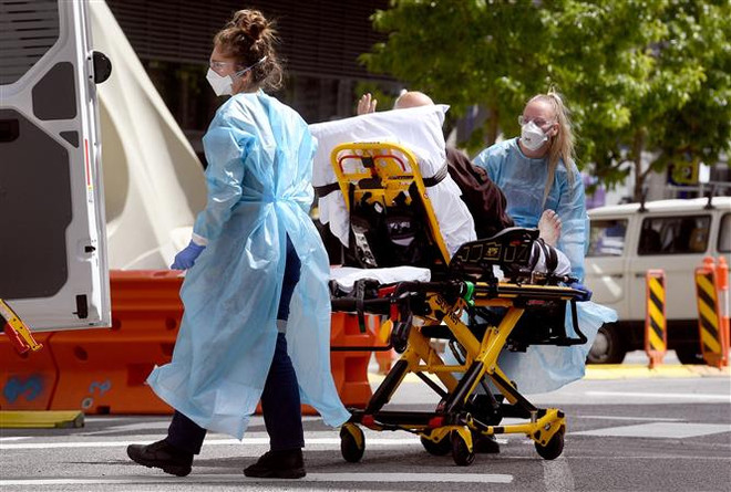 Chuyển bệnh nhân nhiễm COVID-19 tới bệnh viện ở Melbourne, Australia. (Ảnh: AFP/TTXVN) Australia có số ca tử vong do COVID-19 cao nhất những tháng gần đây ảnh 1