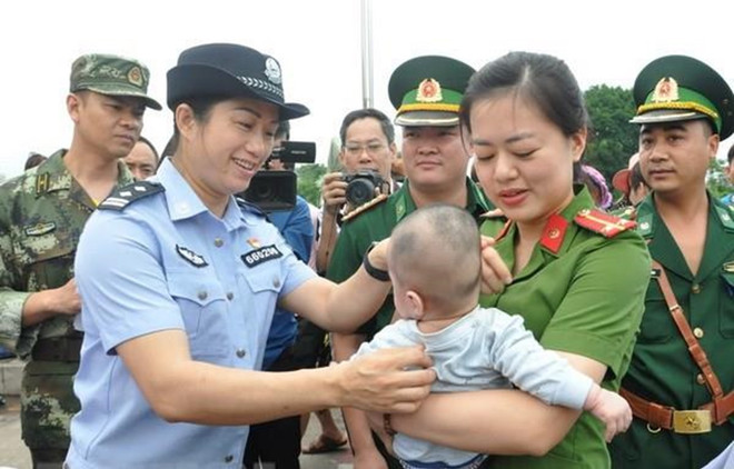 Lực lượng chức năng Việt Nam tiếp nhận em bé bị bán sang Trung Quốc. (Ảnh:Nguyễn Hoàng/TTXVN) Quyết liệt thực hiện nhiều giải pháp ngăn chặn tội phạm mua bán người ảnh 2