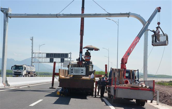 Các nhà thầu thi công hạng mục lắp giá long môn trên tuyến. (Ảnh: Thanh Vân/TTXVN) Các nhà thầu dự án cao tốc Vân Đồn-Móng Cái tăng tốc về đích ảnh 1