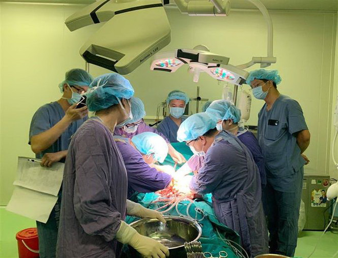 Các bác sỹ Bệnh viện Việt Đức thực hiện một ca phẫu thuật. (Ảnh: TTXVN phát) Hàng chục bệnh nhân đã được chi trả tới tiền tỷ từ bảo hiểm y tế ảnh 2