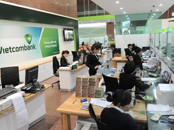 Giao dịch tại Vietcombank. (Ảnh: Vietnam+) Công bố top 10 ngân hàng thương mại Việt Nam uy tín năm 2023 ảnh 1
