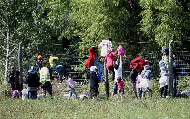 Người di cư vượt qua hàng rào tại khu vực làng Roszke, biên giới Hungary-Serbia. (Ảnh: AFP/TTXVN) Số đơn xin tị nạn tại EU giảm xuống mức thấp nhất trong 8 năm ảnh 1