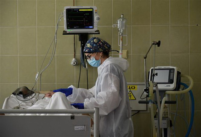 Nhân viên y tế điều trị cho bệnh nhân COVID-19 tại bệnh viện ở Lviv, Ukraine. (Ảnh: AFP/TTXVN) COVID-19: Ukraine, Đức, Ba Lan: số ca mắc mới trong ngày tăng kỷ lục ảnh 1