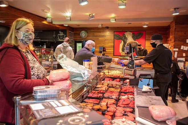 Người dân mua sắm tại một cửa hàng ở Ballymena, Bắc Ireland. (Ảnh: AFP/TTXVN) IMF và WB cảnh báo nguy cơ kinh tế thế giới rơi vào suy thoái ảnh 2