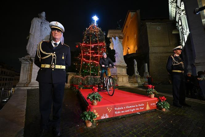 Người dân đạp xe để cung cấp năng lượng thắp sáng cây thông Noel bên ngoài Tòa thị chính Rome ở Quảng trường đồi Capitolinus , ngày 13/12. (Ảnh: AFP/TTXVN) Chuyên gia: Các nước EU trước nguy cơ thiếu khí đốt càng nghiêm trọng ảnh 2