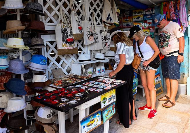 Khách du lịch mua sắm tại cửa hàng lưu niệm ở tỉnh Matanzas, Cuba. (Ảnh: AFP/TTXVN) Cuba công bố các biện pháp "táo bạo" để kiềm chế lạm phát ảnh 1