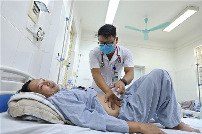 Bác sỹ Bệnh viện đa khoa Đống Đa thăm khám cho bệnh nhân mắc sốt xuất huyết. (Ảnh: Minh Quyết/TTXVN) Số ca mắc sốt xuất huyết tại thành phố Hà Nội vẫn ở mức cao ảnh 1