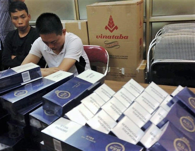 Hai đối tượng cùng tang vật của vụ án (Ảnh: PV/Vietnam+) Bắt giữ 7.500 bao thuốc lá lậu trên đường tuồn về Thủ đô ảnh 1