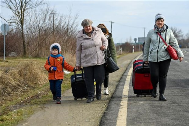 Người dân Ukraine vượt biên sang Hungary để tránh xung đột, ngày 25/2/2022. (Ảnh: AFP/TTXVN) Chính phủ Anh và Ba Lan hợp tác xây 2 ngôi làng tạm trú tại Ukraine ảnh 1