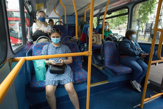 Người dân đeo khẩu trang phòng lây nhiễm COVID-19 trên xe buýt tại London, Anh. (Ảnh: THX/ TTXVN) Nguy cơ châu Âu tái bùng phát dịch COVID-19 vì người dân đi tránh nóng ảnh 4
