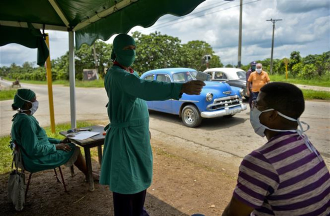 Đo thân nhiệt phòng lây nhiễm COVID-19 tại San Jose de las Lajas, Cuba. (Ảnh: AFP/TTXVN) Nguy cơ châu Âu tái bùng phát dịch COVID-19 vì người dân đi tránh nóng ảnh 3