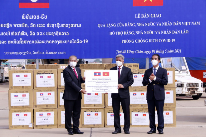 Thứ trưởng Bộ Y tế Nguyễn Trường Sơn đang trao tượng trưng 2 triệu khẩu trang y tế và 200 máy thở và các vật tư y tế là quà tặng của Đảng, Nhà nước và nhân dân Việt Nam dành cho Đảng, Nhà nước và nhân dân Lào trong công tác phòng chống COVID-19. (Ảnh: Phạm Kiên/TTXVN) Việt Nam hỗ trợ vật tư y tế, cử chuyên gia sang trực tiếp giúp Lào ảnh 1