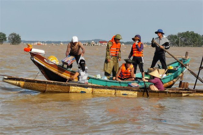Người dân Lệ Thủy, Quảng Bình chèo thuyền đi lấy hàng cứu trợ do địa hình phức tạp khiến lực lượng chức năng không thể tiếp cận. (Ảnh: Thành Đạt/TTXVN) Chủ động kế hoạch xuất cấp hàng dự trữ quốc gia hỗ trợ dân vùng lũ ảnh 1