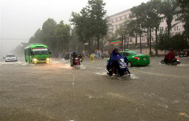 Nhiều tuyến đường thành phố Vinh bị ngập sâu khiến các phương tiện tham gia giao thông gặp nhiều khó khăn. (Ảnh: Tá Chuyên/TTXVN) Các tỉnh từ Thanh Hóa đến Khánh Hòa chủ động ứng phó với mưa, lũ ảnh 1