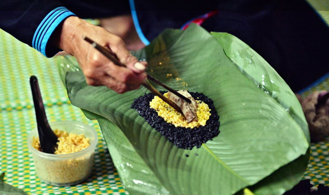 Công đoạn gói bánh. (Nguồn: Báo Ảnh Việt Nam) banh chung den3.JPG